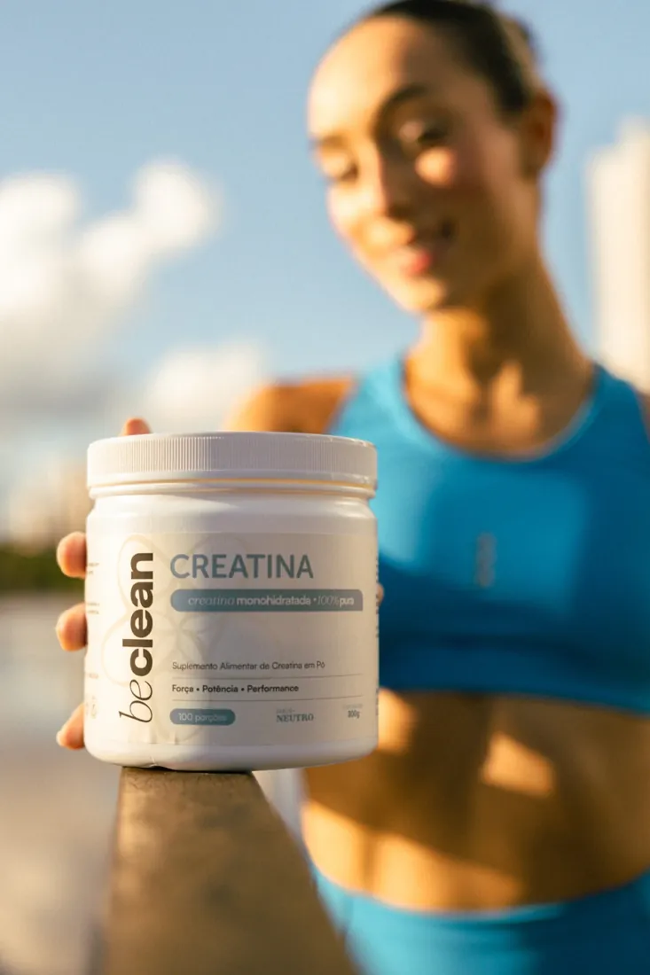 Atleta segurando o pote de Creatina Be Clean